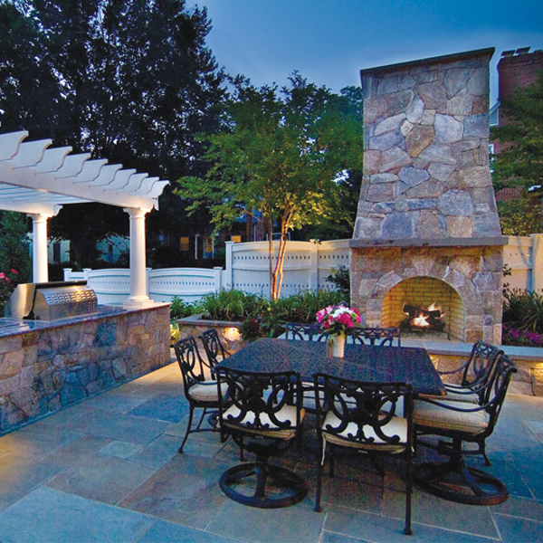 A stone fireplace and outdoor kitchen help frame a landscape, setting the mood for easy al fresco entertaining. LANDSCAPE ARCHITECTURE: Walnut Hill Landscape Company PHOTOGRAPHY: Jay Stearns