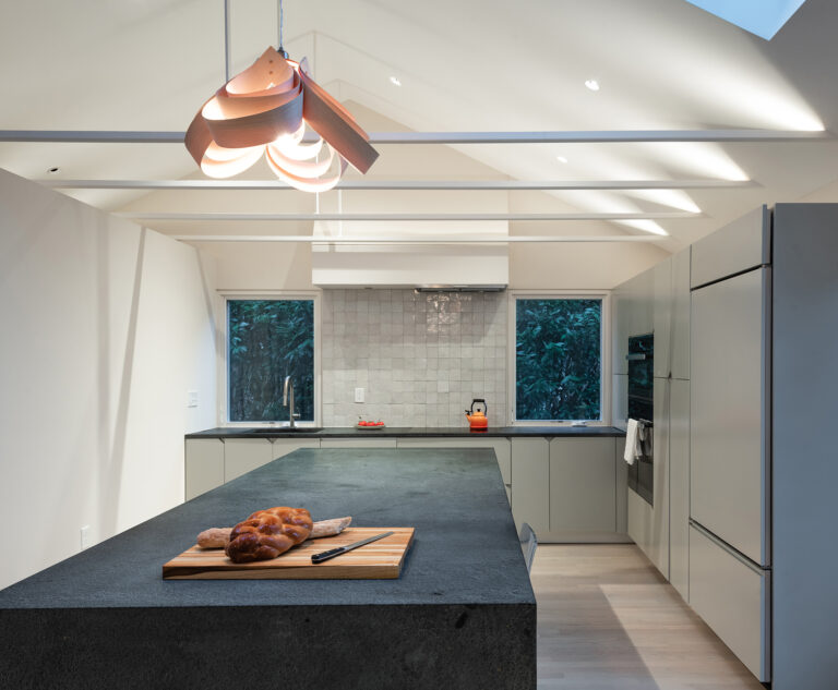 Above the kitchen, the low ceiling was replaced with an open volume spanned by thin steel channel ties with hidden uplights.ARCHITECTURE: EL STUDIO PHOTOGRAPHY: Paul Burk