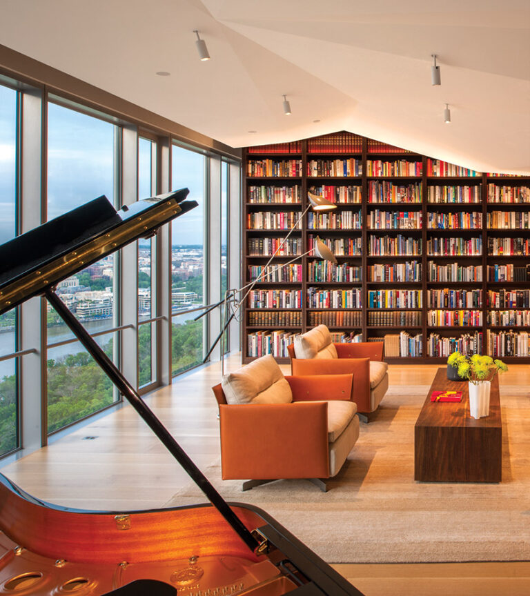 Furnishings in a living/music room are seamlessly integrated with aerial views of the Potomac River and Key Bridge. INTERIOR DESIGN: Baron Gurney Interiors PHOTOGRAPHY: Maxwell Mackenzie