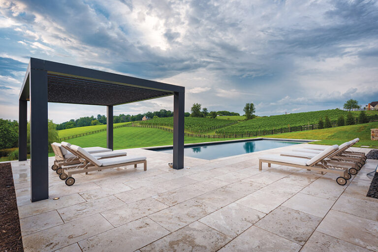 Large-format travertine pool pavers and a clean-lined pergola complement a modern farmhouse surrounded by vineyards in Waterford,Virginia. LANDSCAPE ARCHITECTURE: Colao & Peter, Luxury Outdoor Living PHOTOGRAPHY: JIMI SMITH