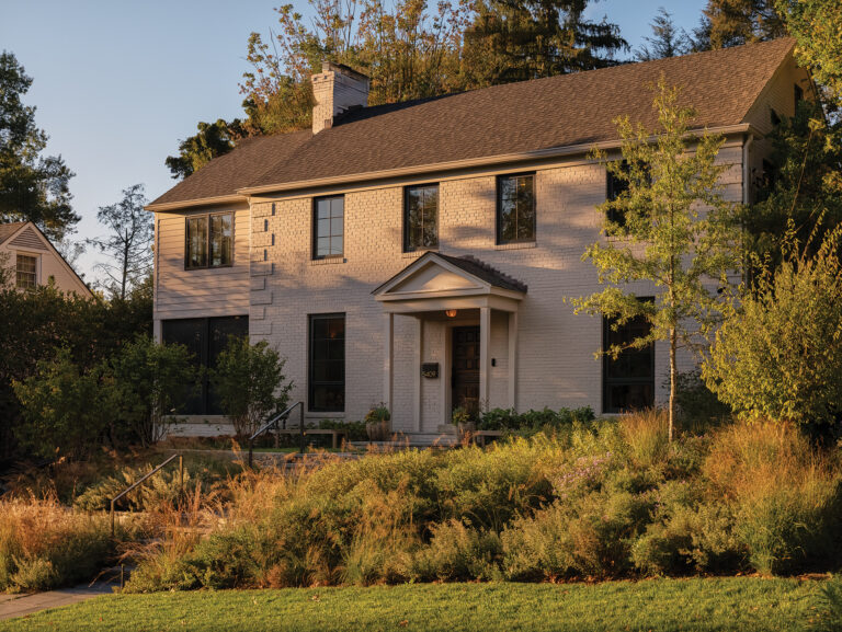 A shot of the front yard reveals the afternoon sun illuminating a tiered garden of perennials.