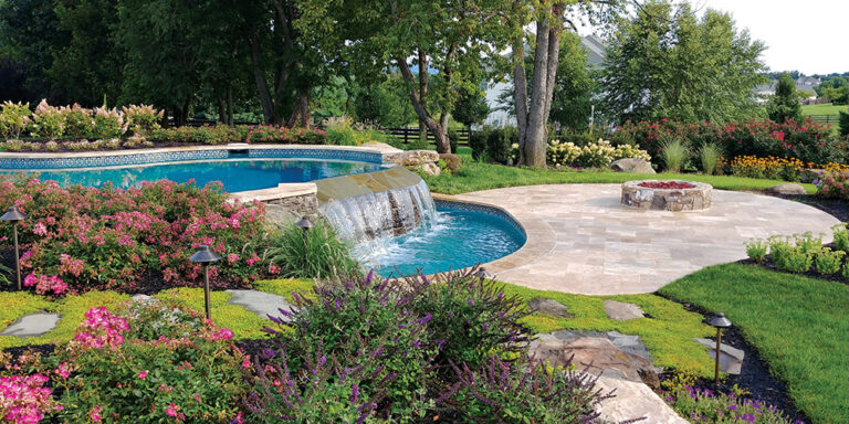 A travertine terrace complete with a fire pit at the edge of a waterfall offers a relaxing destination in Loudoun, Virginia. LANDSCAPE ARCHITECTURE: Colao & Peter Outdoor Environments