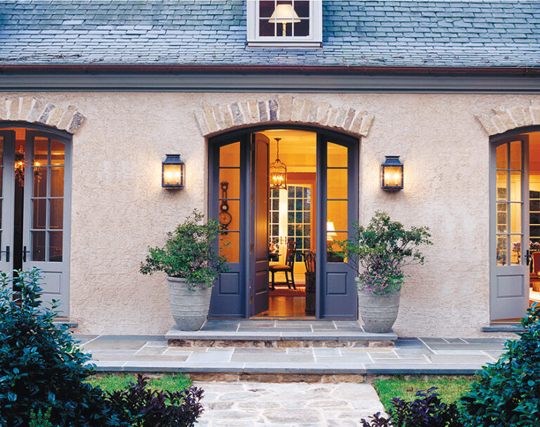 The French Country Home remodel transformed a 1950s split level; a series of French doors with fieldstone arches replaced the front facade. ARCHITECTURE: Donald Lococo Architects, LLC PHOTOGRAPHY: WALTER SMALLING