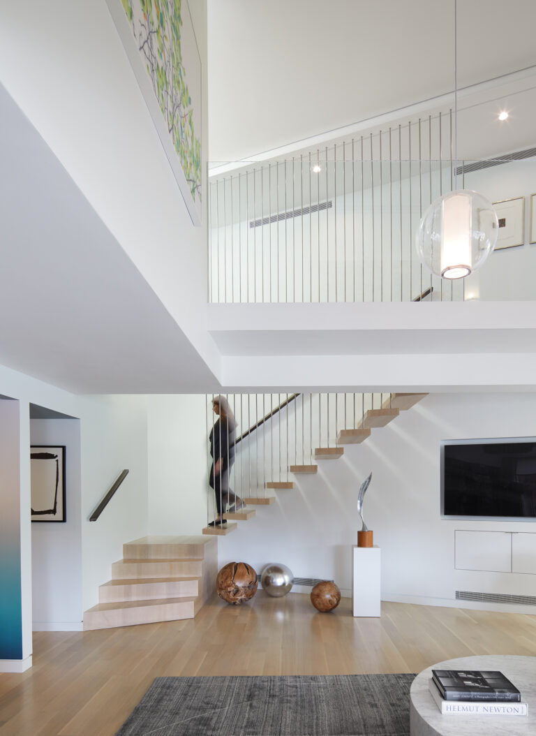 The unit’s shape is resolved by the stair, which connects a double-height living space to the upper level.