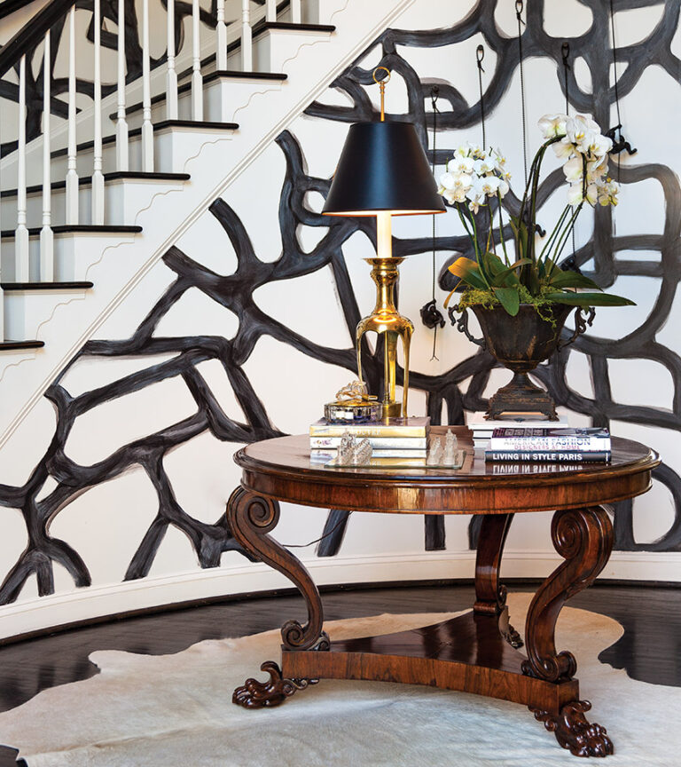 An eye-catching entry boasts an antique table on a cowhide rug. INTERIOR DESIGN: Farnady Interiors PHOTOGRAPHY: Gwin Hunt