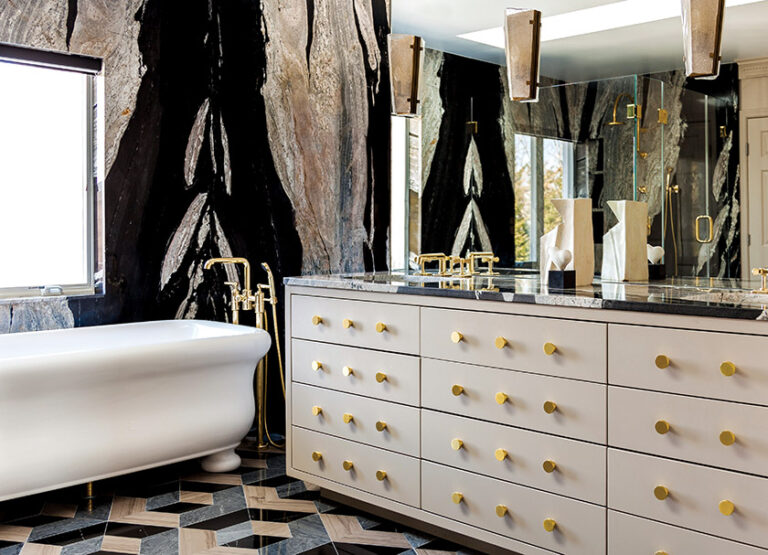 A master bath features Waterworks fixtures, a multi-hued stone floor and walls clad in swirling marble. INTERIOR DESIGN: Farnady Interiors PHOTOGRAPHY: Gwin Hunt