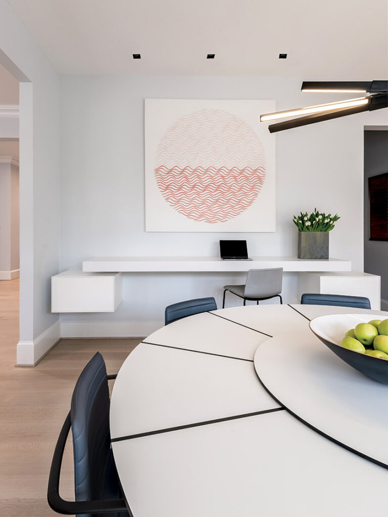 A Stickbulb fixture hangs above an Arthur high-resin dining table with seating from Andreu World; a Boffi white-lacquered custom workstation lines one wall. INTERIOR DESIGN: Baron Gurney Interiors, LLC PHOTOGRAPHY: Petrini Studio