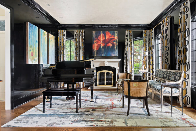 Walls faux finished in high-gloss black are a backdrop to striking art in a McLean music room where cane-backed Century chairs sit atop an abstract rug.