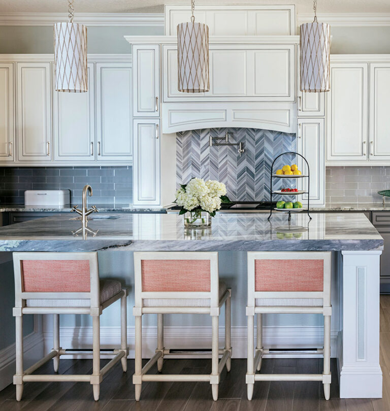 Coral-backed stools and mini-pendants accent a soft-gray kitchen with quartzite countertops. INTERIOR DESIGN: Lorna Gross Interior Design PHOTOGRAPHY: NICK MELE PHOTOGRAPHY