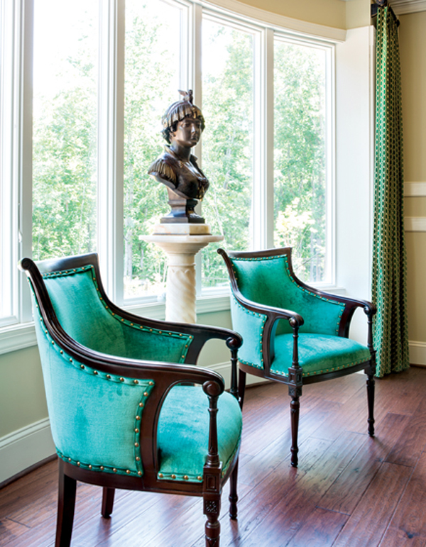 A 19th-century Italian empress bronze bust centers a library while rich velvet fabric in jade adds luxury to a pair of fauteuil chairs. INTERIOR DESIGN: Lorna Gross Interior Design PHOTOGRAPHY: Angie Seckinger