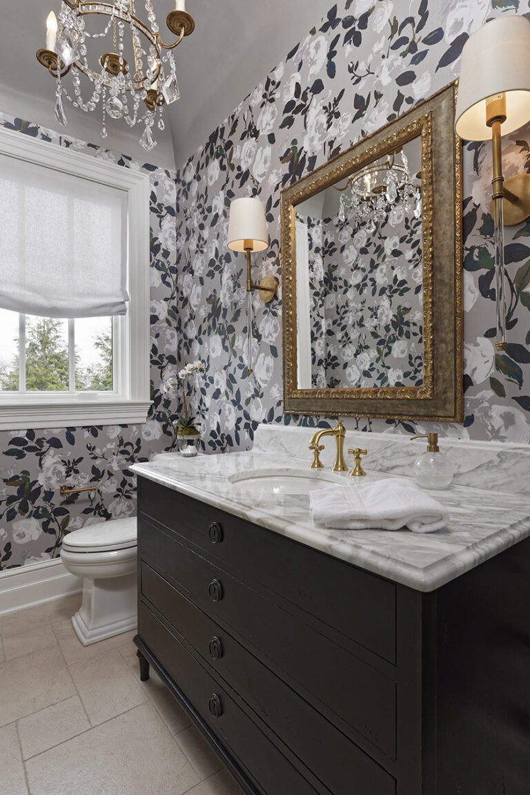 Enveloped by this floral wallcovering by Romo, paired with Visual comfort sconces, and mini chandelier, this powder room is refreshingly sophisticated. INTERIOR DESIGN: MAX Interiors PHOTOGRAPHY: Bob Narod