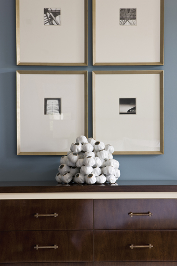 A living room vignette combines color, scale and form by pairing ceramics and photographs against a blue wall. INTERIOR DESIGN: Sandra Meyers Design StudioPHOTOGRAPHY: Gordon Beall