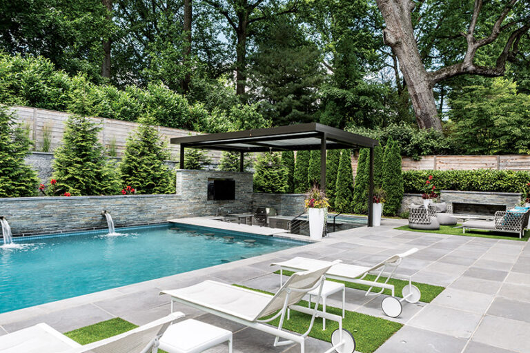 A Bethesda project features a swimming pool with a swim-up bar, an outdoor kitchen shaded by a retractable-top pergola and a stone fireplace; both projects won national Grand Awards. LANDSCAPE DESIGN: Fine Earth Landscape PHOTOGRAPHY: Angie Seckinger