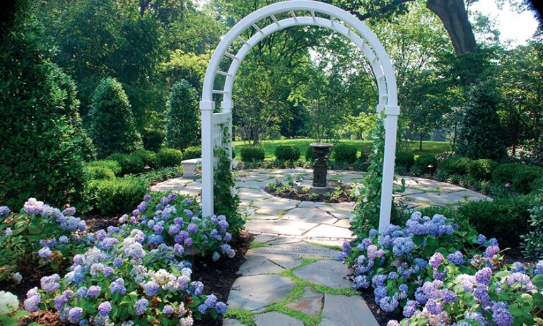 The vice president’s Family Heritage Garden boasts an entrance framed by an Azek arbor, a delightful fountain and an irregular flagstone patio interplanted with mazus ground cover. LANDSCAPE DESIGN: Fine Earth Landscape PHOTOGRAPHY: Hilary Schwab