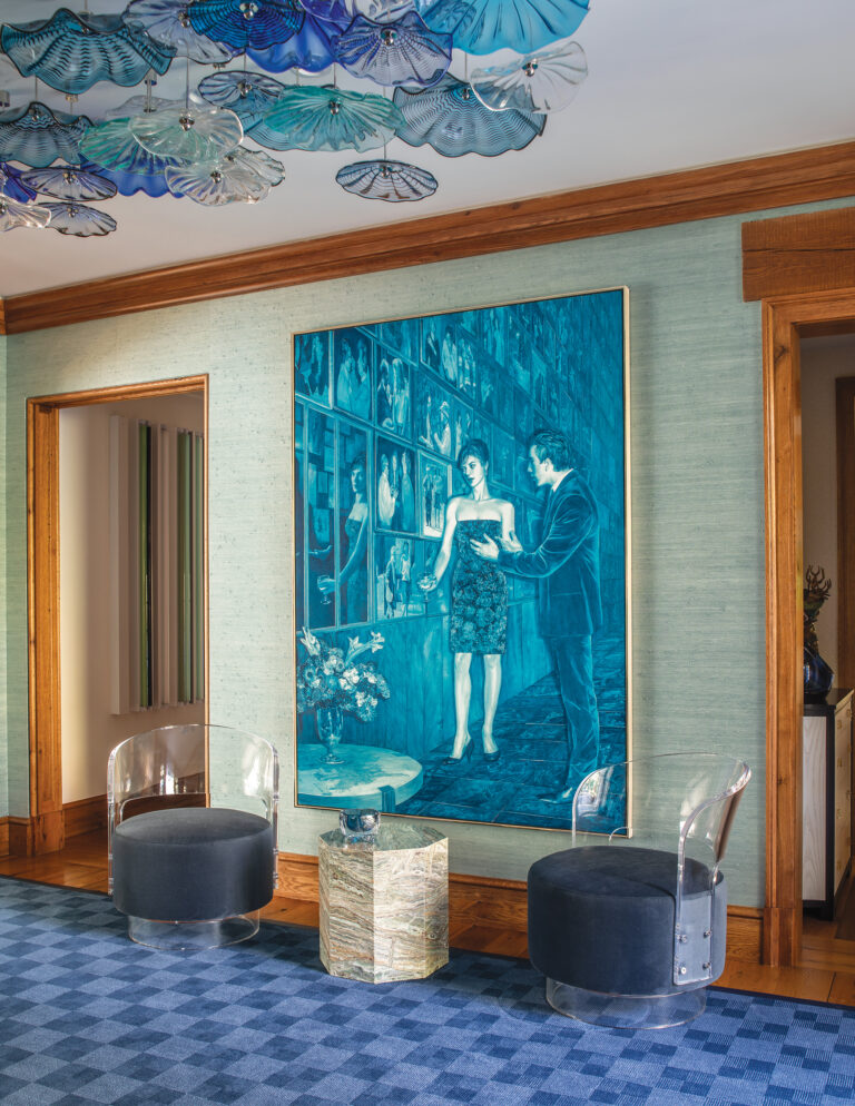 A color-forward foyer combines art by Mark Tansey with a custom glass light fixture by Wired Designs and an area rug from Doris Leslie Blau.