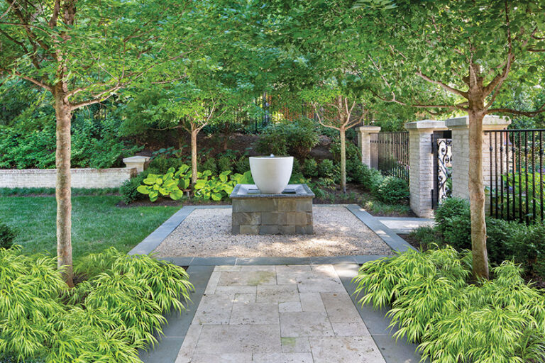 A custom water feature comprised of an urn spilling into a Pennsylvania bluestone basin creates a focal point in a courtyard covered in crushed gravel. LANDSCAPE ARCHITECTURE: Surrounds Landscape Architecture + Construction PHOTOGRAPHY: Morgan Howarth