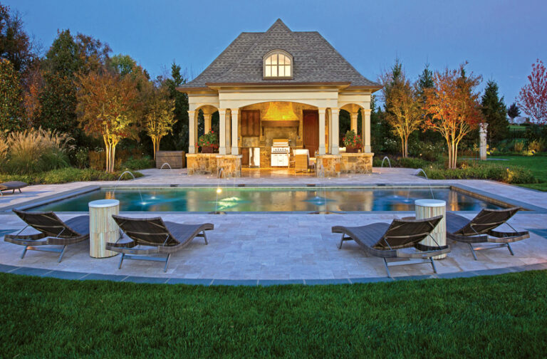 An elegant country pool environment is surrounded by a travertine patio with a custom covered outdoor kitchen. LANDSCAPE ARCHITECTURE: Surrounds Landscape Architecture + Construction PHOTOGRAPHY: Greg Hadley