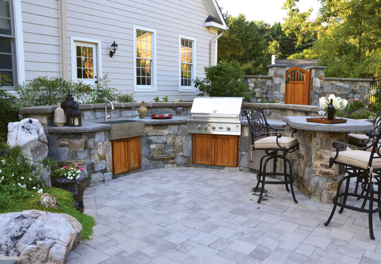 A bar and grill are accented with cedar cabinet doors, a polished granite sink and a flagstone countertop. LANDSCAPE ARCHITECTURE: Surrounds Landscape Architecture + Construction PHOTOGRAPHY: Howard Cohen
