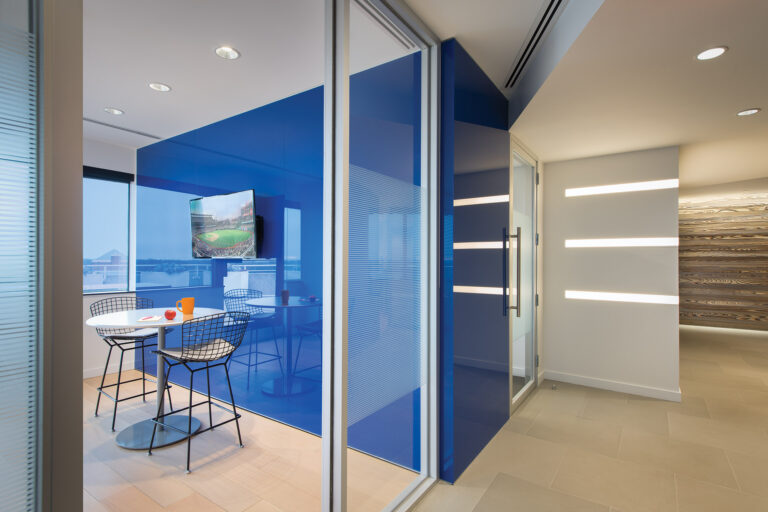 Back-painted glass walls by Clarus reflect sky-level views in a niche containing Bertoia barstools and a Knoll table. INTERIOR DESIGN: Baron Gurney Interiors, LLC PHOTOGRAPHY: John Cole