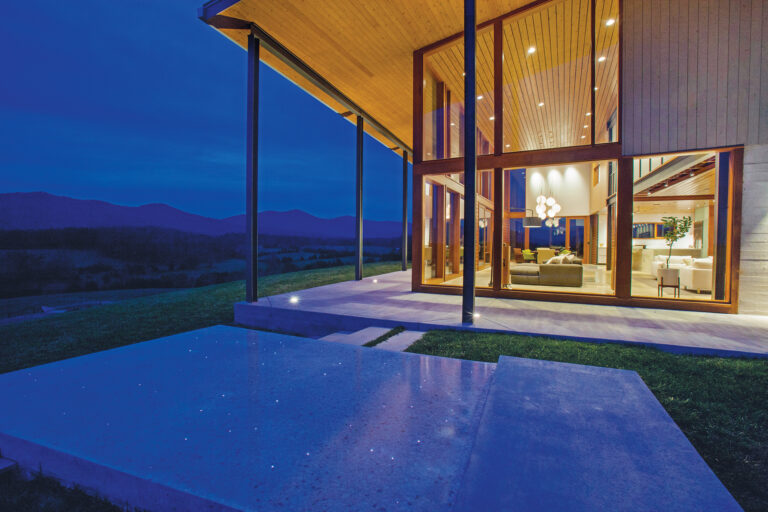 A glass-walled structure promotes an inside-outside connection, overlooking panoramic views of Rapidan Valley.