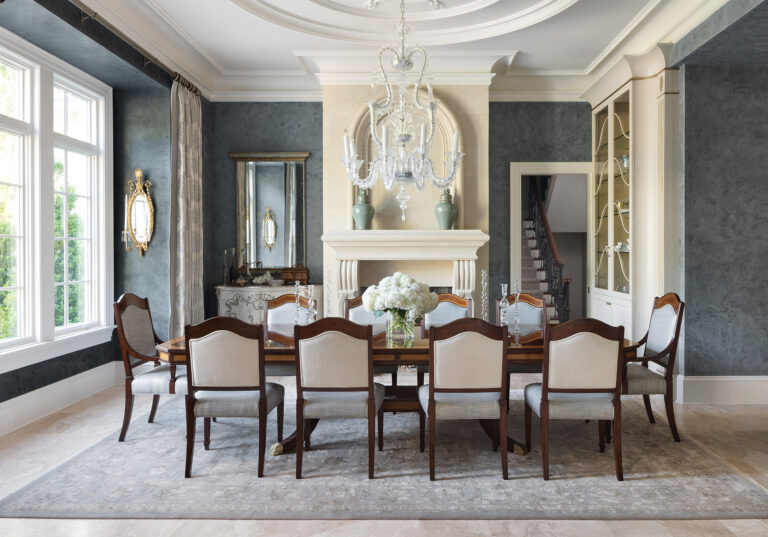 The dramatic dining room boasts Venetian plaster walls, an elegant crystal chandelier and an overscaled limestone fireplace. INTERIOR DESIGN: Interior Concepts, Inc. PHOTOGRAPHY: Stylish Productions