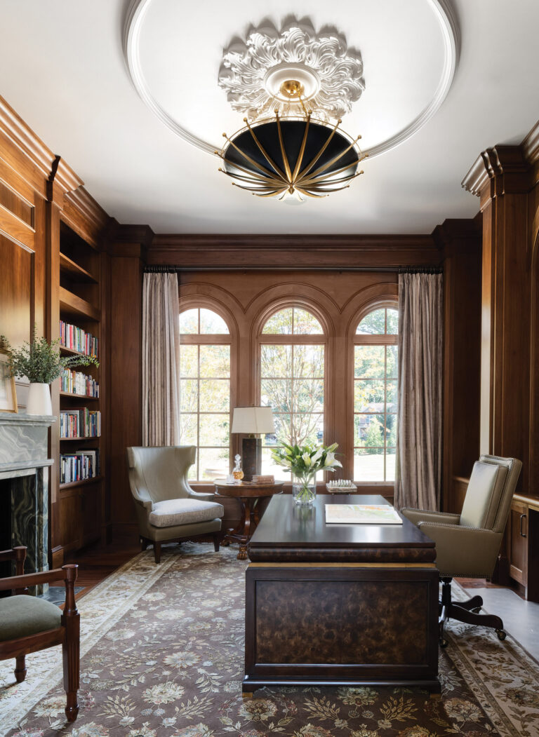 A library paneled in light walnut displays a handsome stone fireplace. INTERIOR DESIGN: Interior Concepts, Inc. PHOTOGRAPHY: Stylish Productions