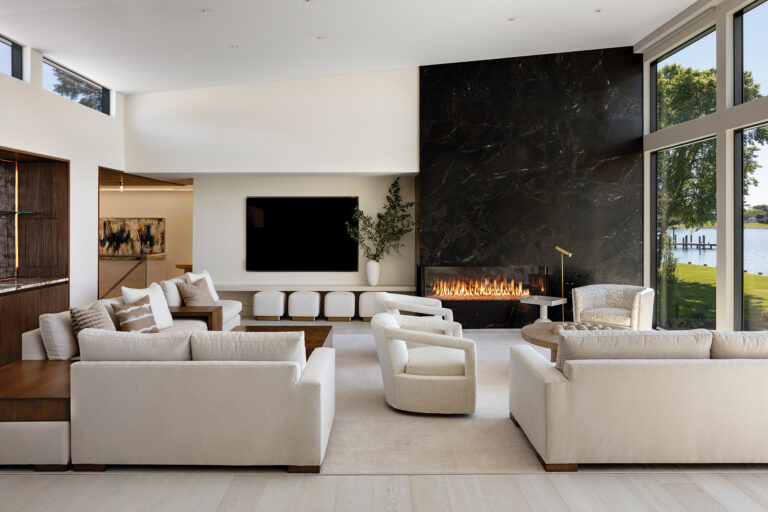 Inside, the family room features a leathered-granite fireplace and a wet bar. The open kitchen and dining area offer unencumbered water vistas. ARCHITECTURE: The Drawing Board, Inc. PHOTOGRAPHY: Jennifer Hughes