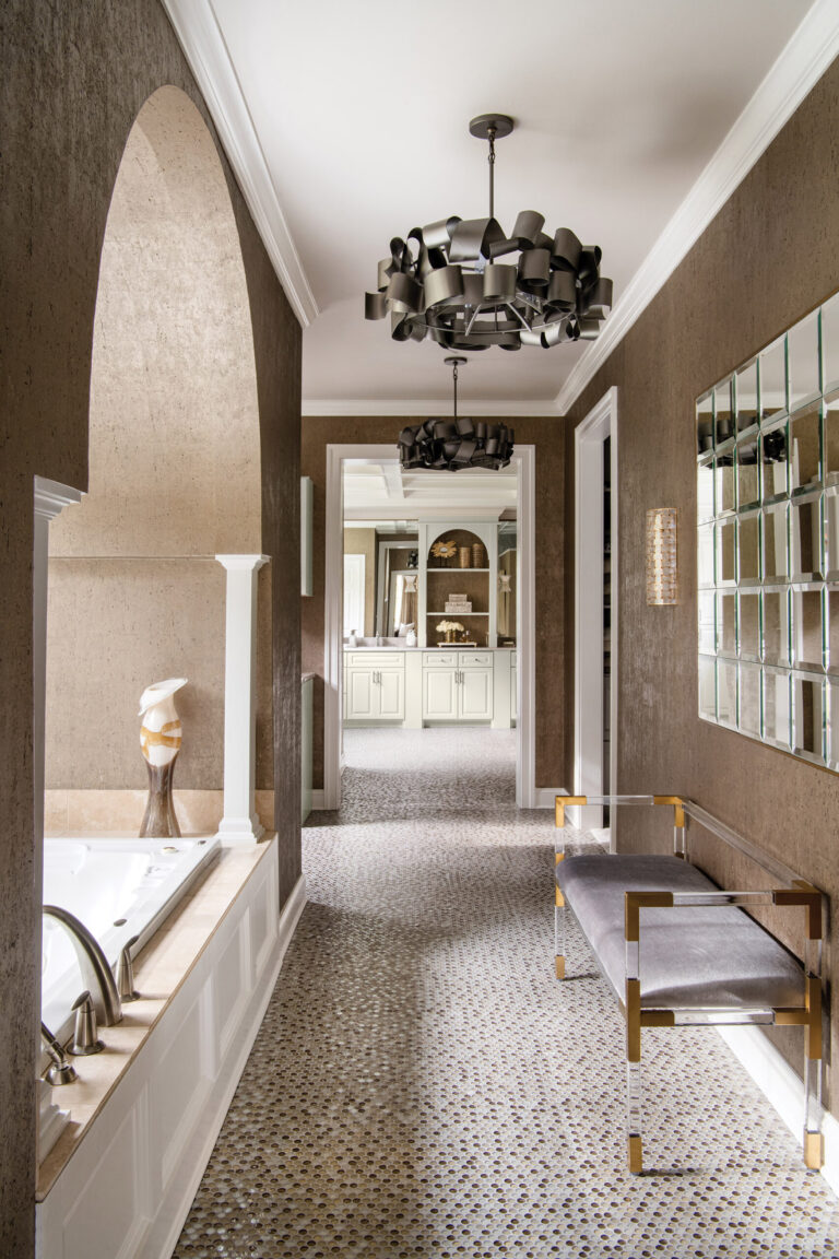 A glam bathroom features flooring in glass-mosaic tile reminiscent of sequins; metallic cork wall covering adds shimmer. INTERIOR DESIGN: Amanda Friend Interior Design PHOTOGRAPHY: Robert Radifera