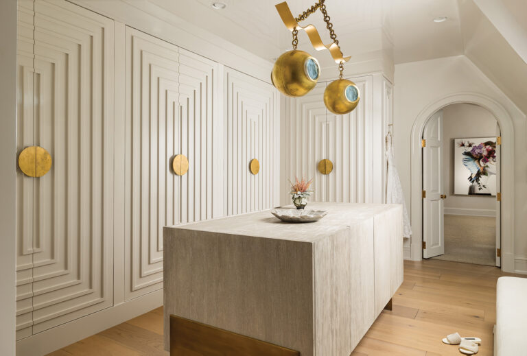 Meticulously trimmed and detailed closet doors line the luxe entrance to a primary suite.