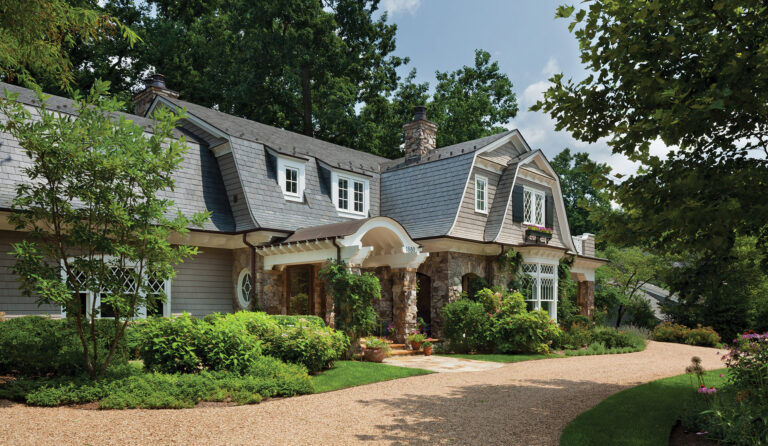 A gambrel roof, flared eaves and Tudor-style windows add elegance to a classic, New England Shingle-style residence. ARCHITECTURE: Harrison Design PHOTOGRAPHY: Gordon Beall