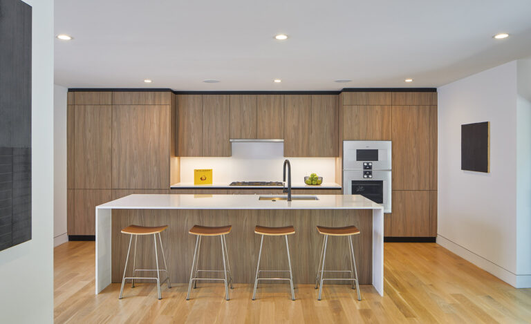 A modern kitchen boasting sleek walnut cabinets by Scavolini, Gaggenau appliances and an island with white quartz coun-tertops. ARCHITECTURE: MCDStudio PHOTOGRAPHY: Anice Hoachlander