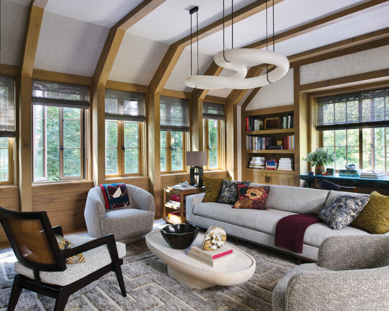 A DC family room was made cozy by a beamed, linen-clad ceiling, textured-plaster walls and a hand-knotted rug; a sculptural, alabaster light fixture makes a modern statement.