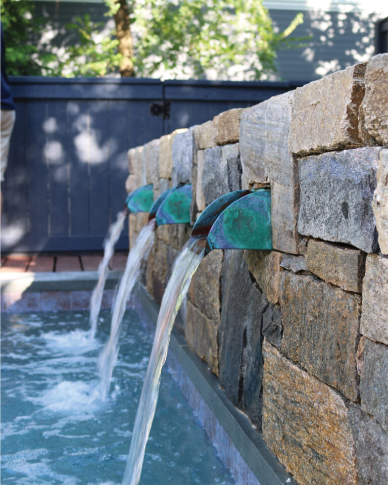 Copper scuppers recessed into a stone wall create tranquil sounds as water spills into a pool below. LANDSCAPE ARCHITECTURE: Walnut Hill Landscape Company