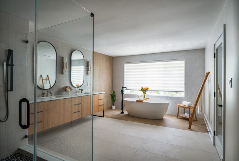 A freestanding soaking tub set against textured wall coverings and bamboo paneling creates a tranquil focal point.