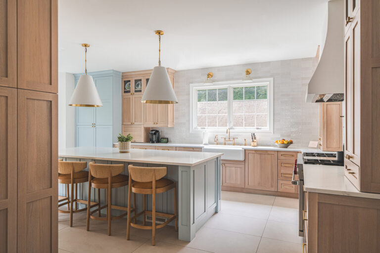 Mediterranean warmth and Scandinavian simplicity meet in a Bethesda kitchen. Cabinets in soft blue offset natural wood tones and the white-tile backsplash.