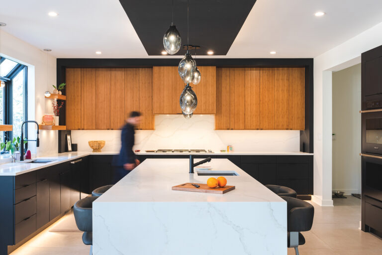 Sustainable bamboo upper cabinetry pairs with black base cabinets in a contemporary Bethesda kitchen; sculptural glass pendants complete the look.