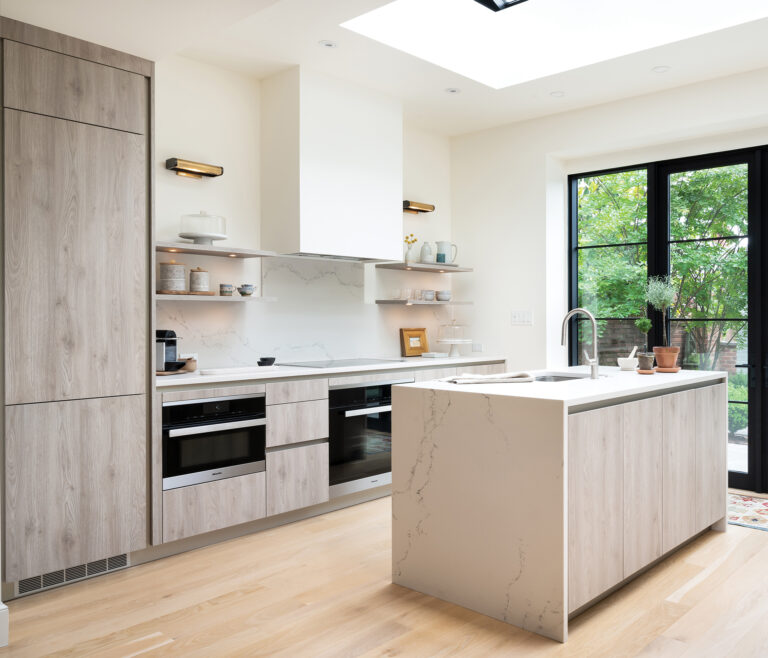 In an Old Town Alexandria kitchen, the wood-grain cabinet finish creates a connection to nature, visible through French doors.