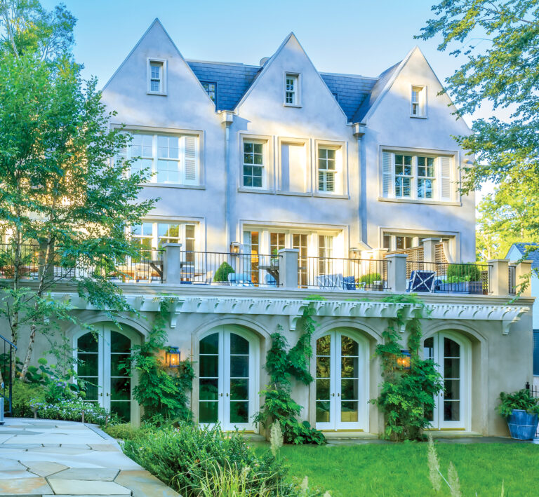 A triple-gabled rear façade, part of an expansive addition, reflects the elegance and grandeur of a 1930s fieldstone Colonial Revival home.